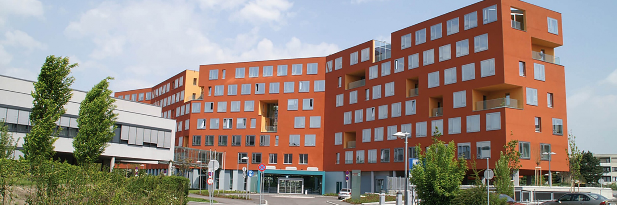 Futuristisch wirkendes Gebäude der Wirtschaftskammer Niederösterreich mit vielen quadratischen Fenstern und oranger Fassade