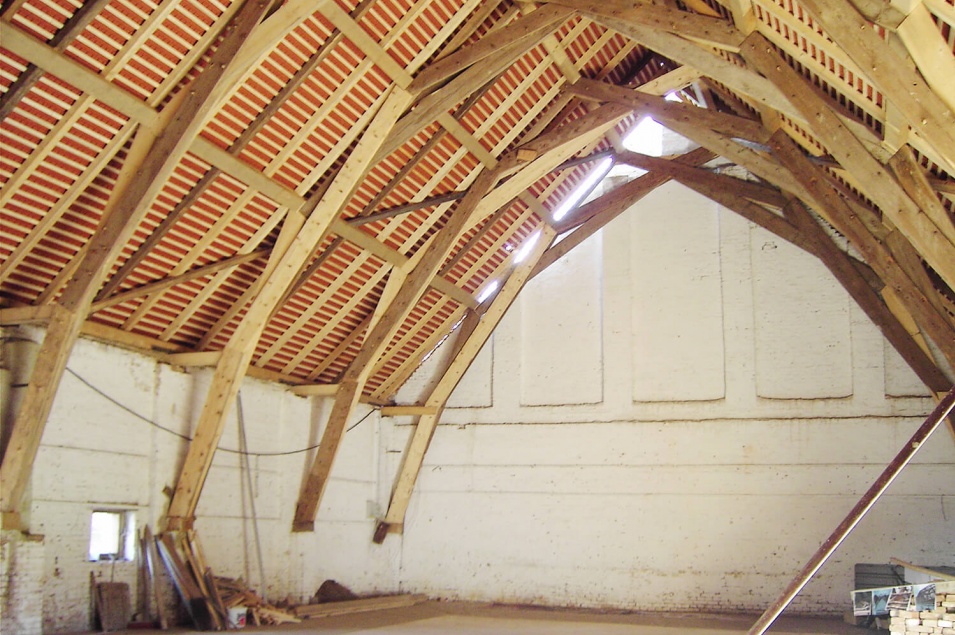 Raum mit Wänden aus Beton und Holzüberdachung in Form eines Schiffsrumpfes