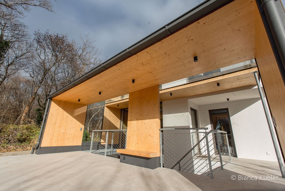 Eine überdachte Terrasse aus Holz und asphaltiertem Boden