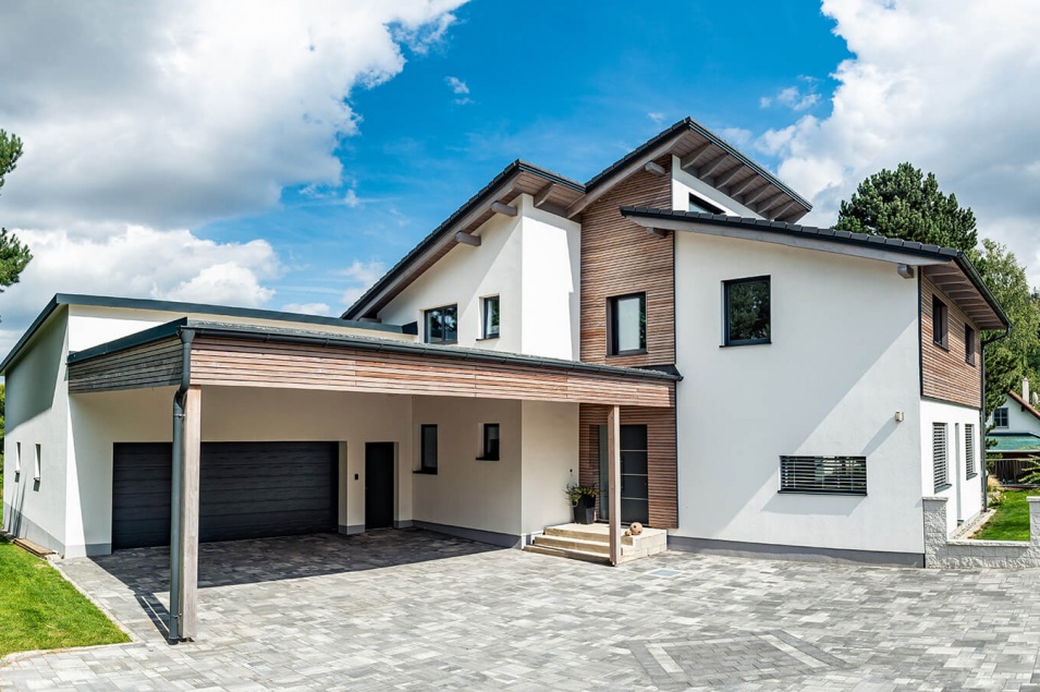 Großes Wohnhaus mit einzelnen Holzdetails und einer Garage