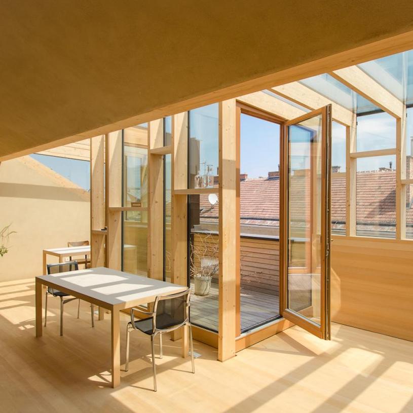 Dachgeschoss aus reinem Holz mit kleiner Terrasse und großen Fenstern