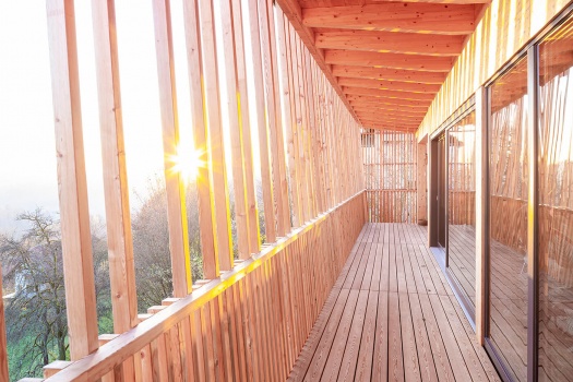 Ein Balkon aus Holz mit großen Fenstertüren und Holzboden