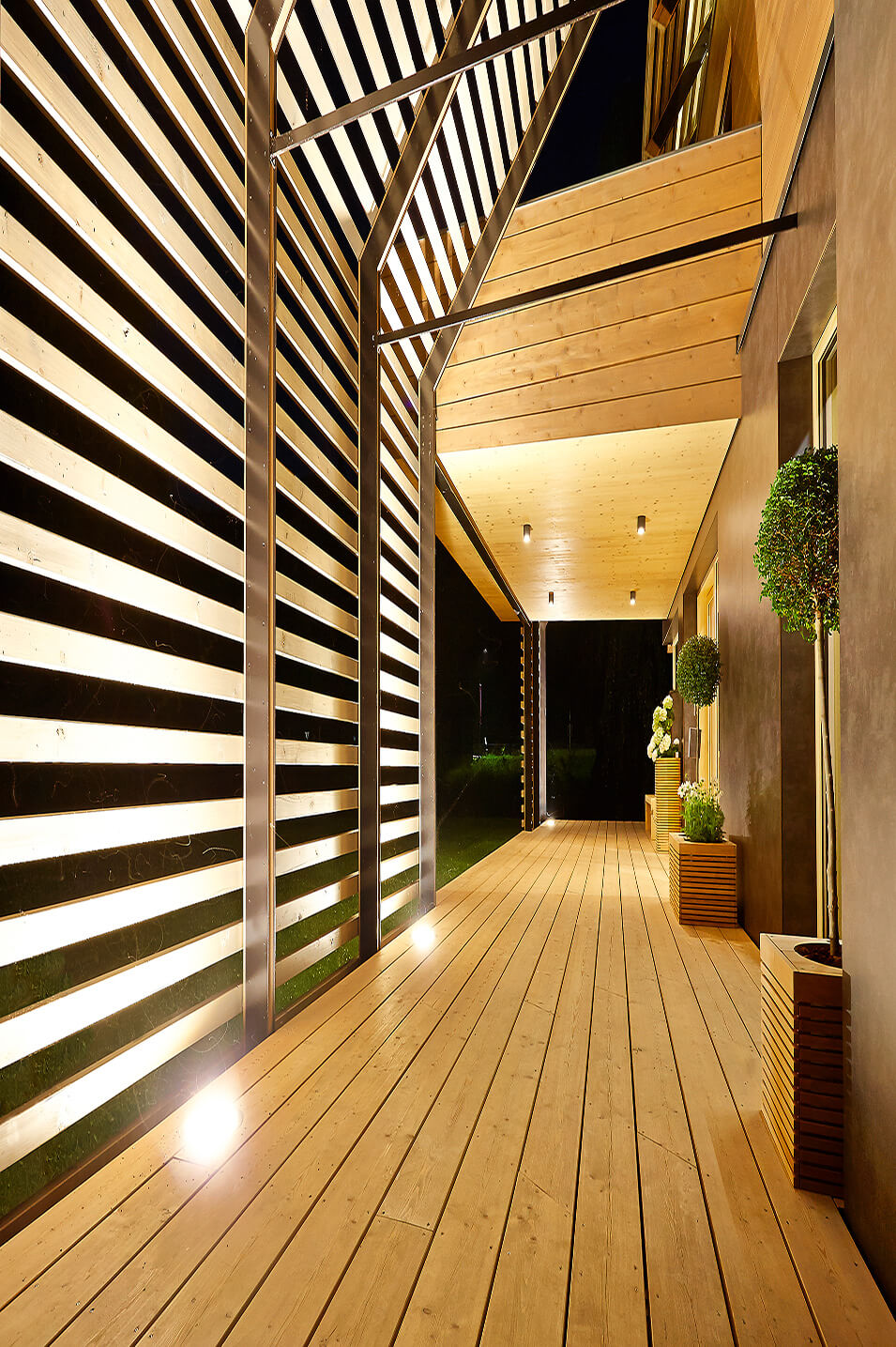 Eine halboffene Terrasse mit starker Beleuchtung und Holzboden
