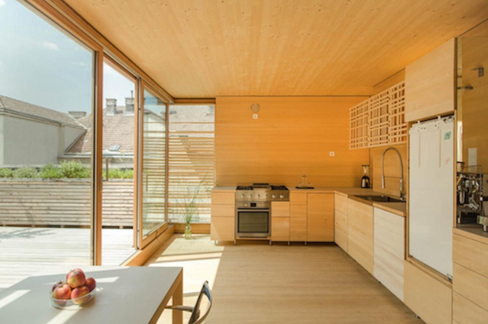 Raum mit Wänden und Boden aus Holz und Küche in Holzoptik