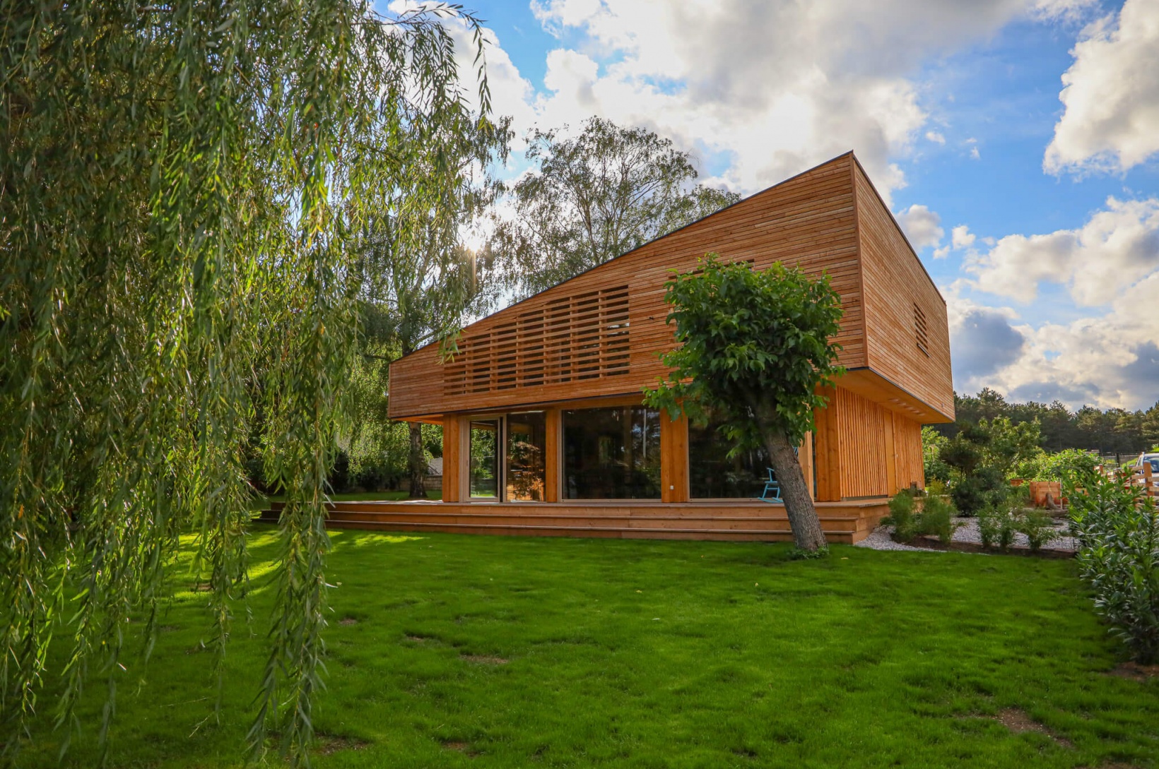 Futuristisches Wohnhaus aus Holz befindet sich von Bäumen umgeben im Grünen|wohnhaus-futuristisch-im-gruenen_kirchberger-holzbau